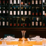 Table set with a decanter before a shelved red-wine wall at La Bodeguilla Palma