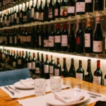 Set table against a backlit wall of wine bottles at La Bodeguilla Palma