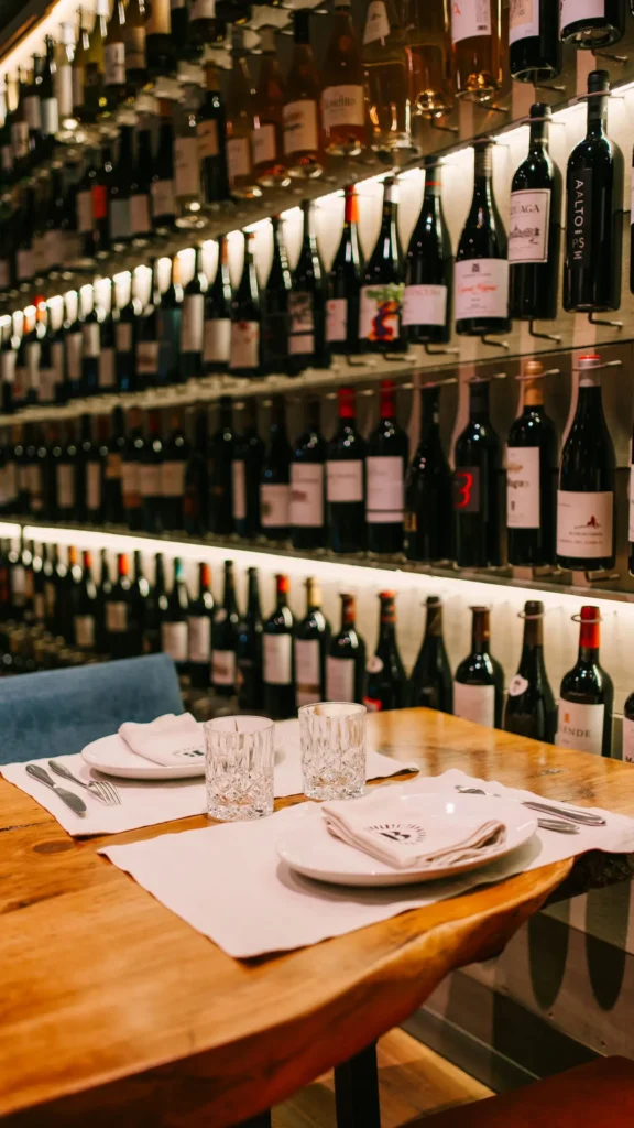 Set table against a backlit wall of wine bottles at La Bodeguilla Palma