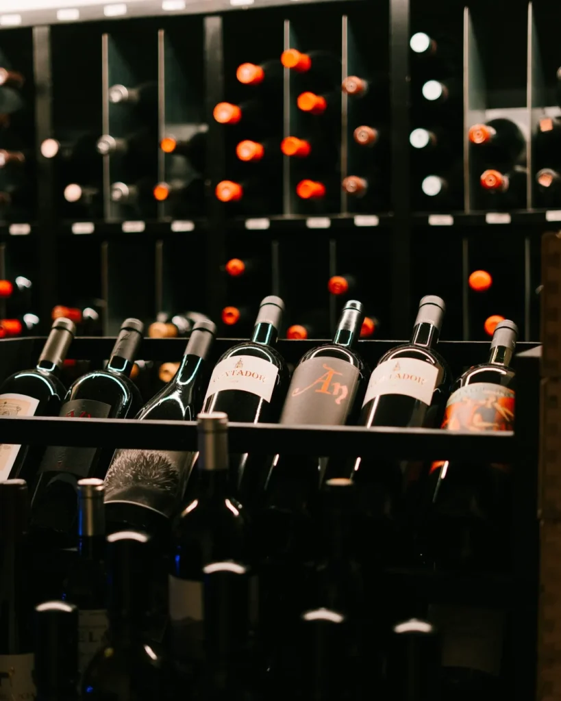 Close-up of bottles stacked in the black wine racks at La Bodeguilla Palma