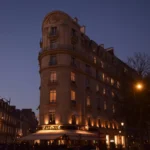Full Haussmannian corner building glowing at twilight above the lavenue awning at lavenue Paris