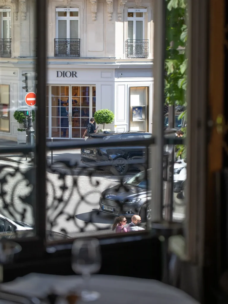 View through the window to the Dior boutique across Avenue Montaigne from a set table at lavenue Paris