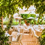 Dining terrace framed by climbing greenery and parasols at Loulou Restaurant Saint-Tropez
