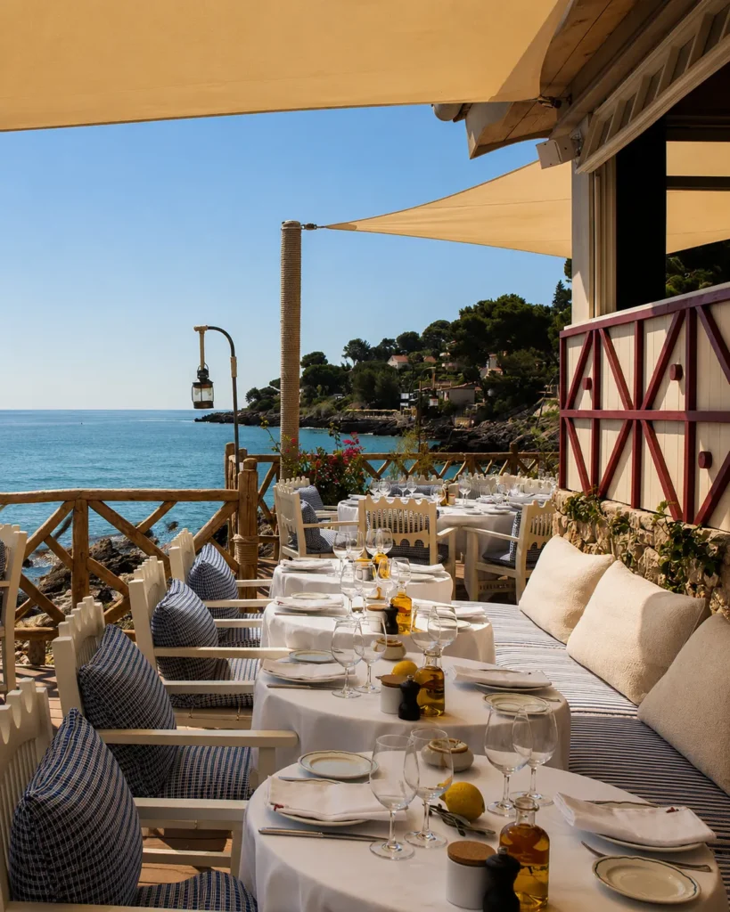 Set terrace tables under sail shades overlooking the coast at Loulou Restaurant Saint-Tropez