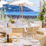 Set tables under white parasols facing the bay at Loulou Restaurant Saint-Tropez