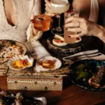Guests toasting cocktails over scallops, ceviche and small plates at Manko Paris
