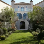 Turreted château exterior with a double staircase and manicured lawn at Matsuhisa Saint-Tropez