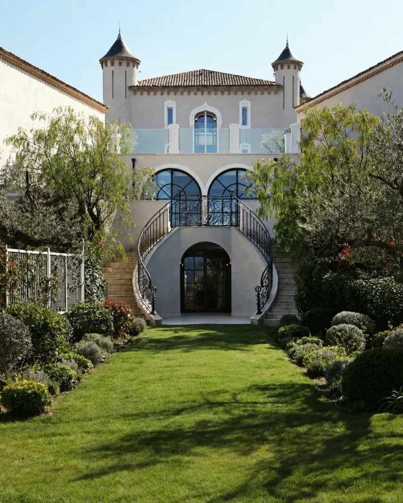 Turreted château exterior with a double staircase and manicured lawn at Matsuhisa Saint-Tropez