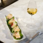 Miso-glazed fish bites on lettuce leaves served with white wine at Matsuhisa Saint-Tropez