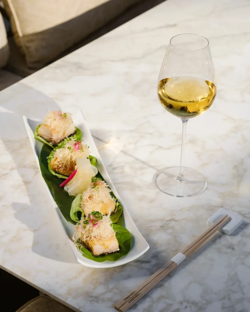 Miso-glazed fish bites on lettuce leaves served with white wine at Matsuhisa Saint-Tropez