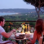 Couple dining at a terrace table overlooking the bay at dusk at Matsuhisa Saint-Tropez