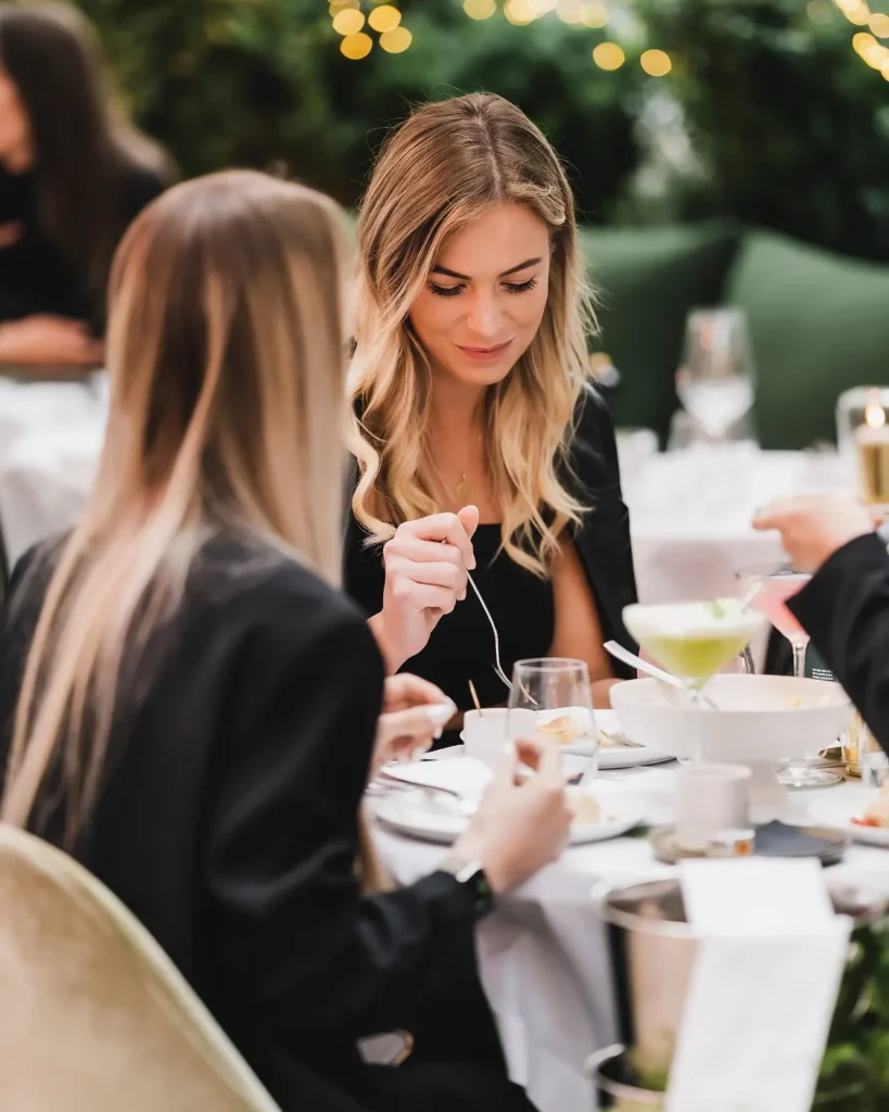 Guest dining over cocktails amid greenery and fairy lights at Monsieur Bleu Paris