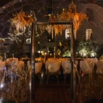Illuminated winter dining dome with hanging birdcages and fur-draped chairs at night at Monsieur Bleu Paris