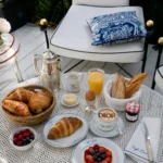 Breakfast spread of viennoiseries, coffee and fruit tart on branded tableware at Monsieur Dior des Lices Saint-Tropez by Mauro Colagreco