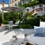 Coffee and pastries on a lounger with a Christian Dior toile cushion on the terrace at Monsieur Dior des Lices Saint-Tropez by Mauro Colagreco