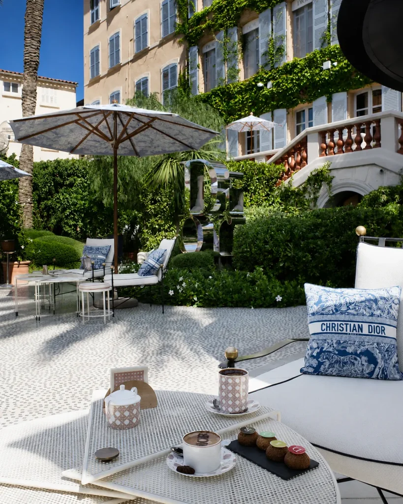 Coffee and pastries on a lounger with a Christian Dior toile cushion on the terrace at Monsieur Dior des Lices Saint-Tropez by Mauro Colagreco