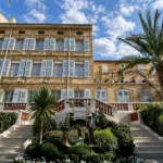 Mirrored Dior sculpture in the garden below the shuttered facade at Monsieur Dior des Lices Saint-Tropez by Mauro Colagreco