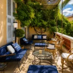 Covered terrace lounge with navy sofas and toile cushions under a vine-shaded pergola at Monsieur Dior des Lices Saint-Tropez by Mauro Colagreco