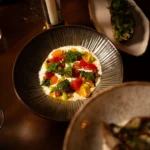 Creamy burrata dish with heirloom tomatoes and herbs served at NAŌ Saint-Tropez