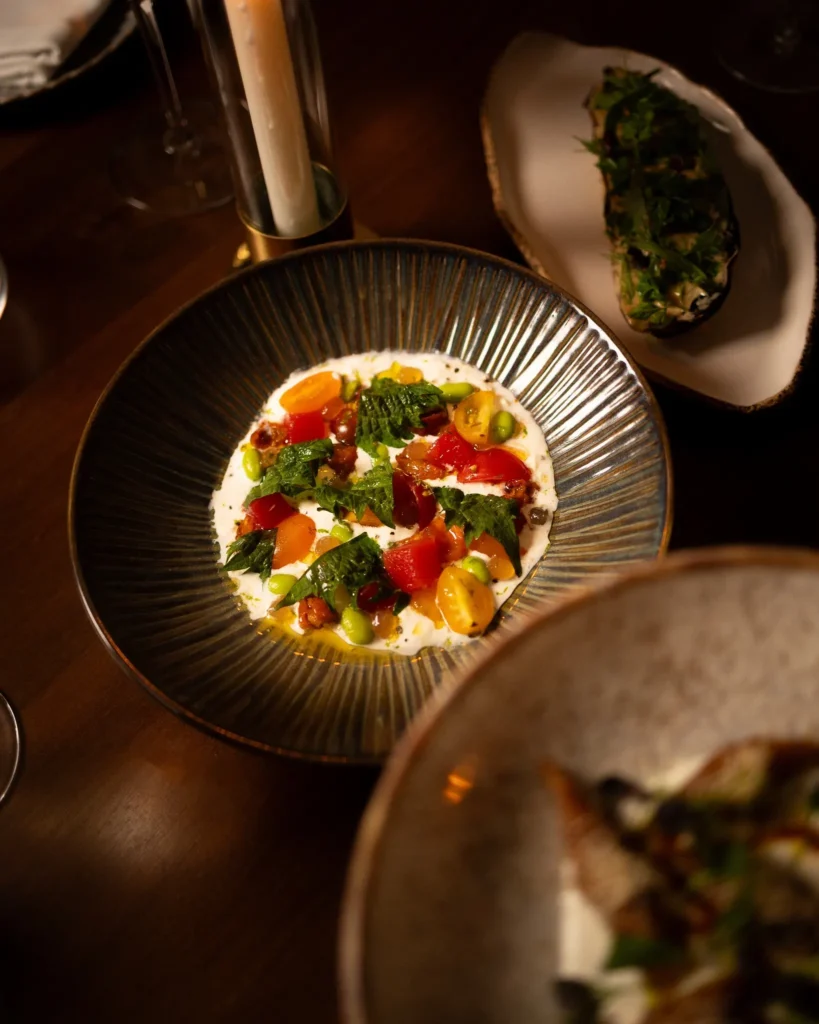 Creamy burrata dish with heirloom tomatoes and herbs served at NAŌ Saint-Tropez