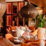 Lounge seating at NAŌ Saint-Tropez with orange velvet chairs and rattan lighting