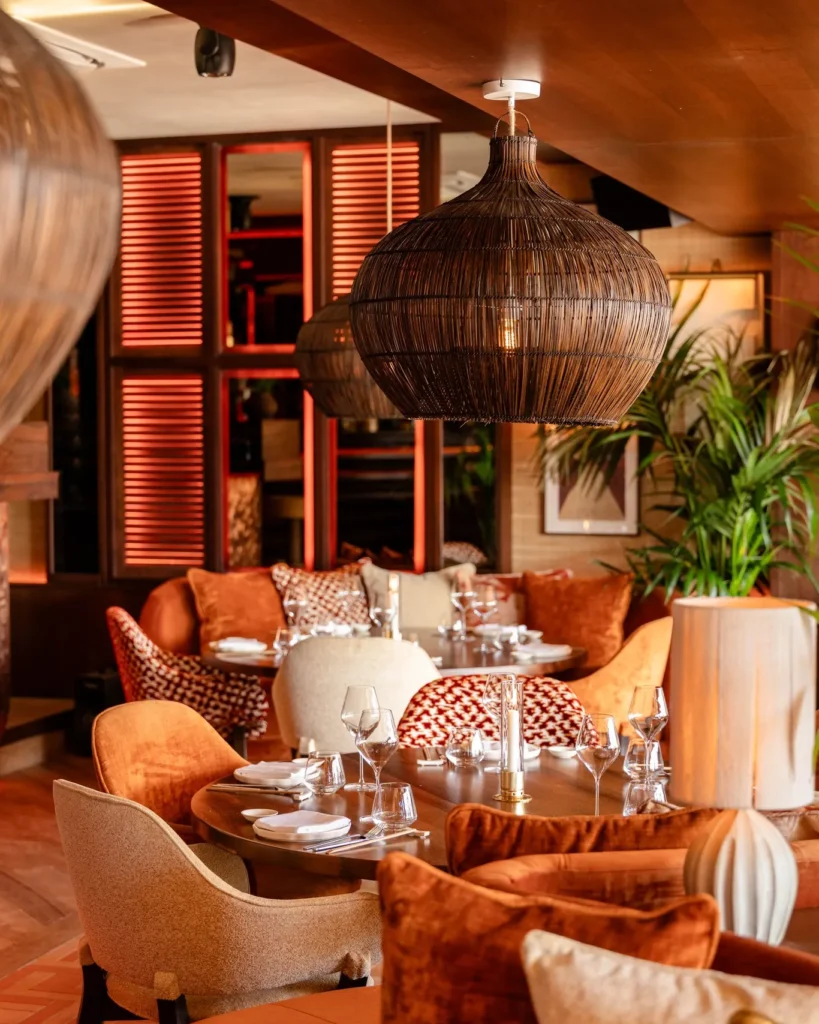 Lounge seating at NAŌ Saint-Tropez with orange velvet chairs and rattan lighting