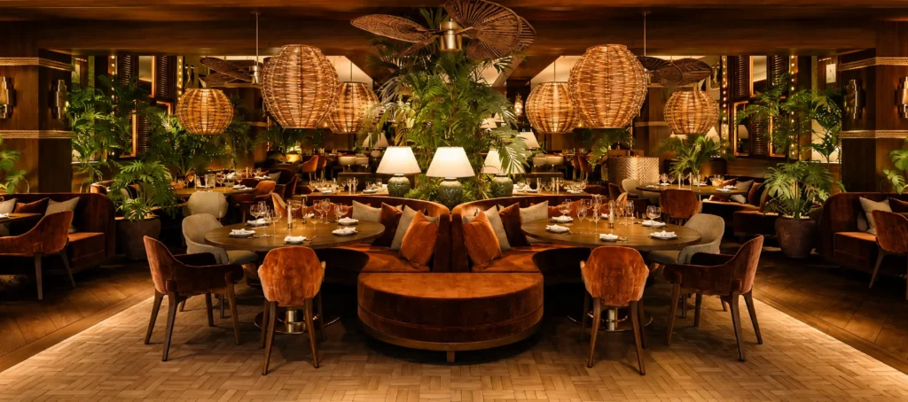 Main dining room at NAŌ Saint-Tropez with rattan pendant lights and central round booth