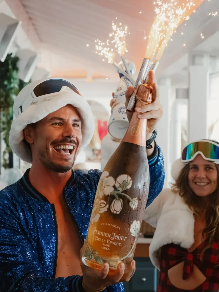 Guests in sequins celebrating with a sparkler-topped champagne bottle at Nikki Beach Saint Barth