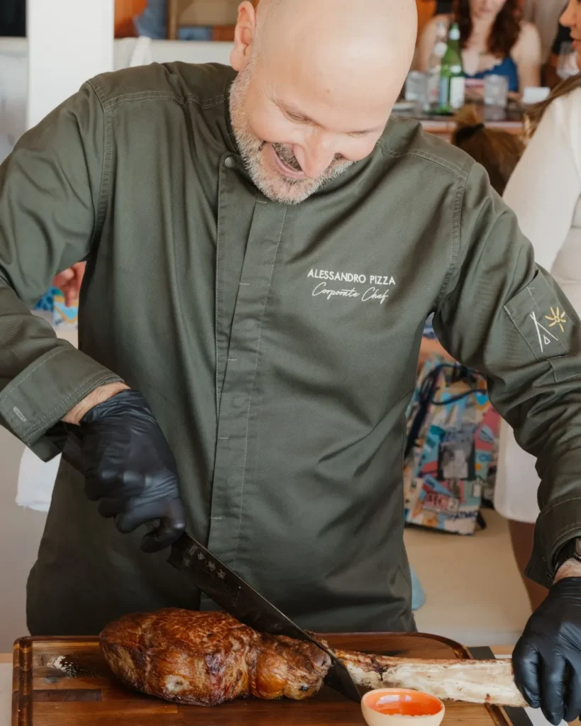 Chef carving a tomahawk steak tableside at Nikki Beach Saint Barth