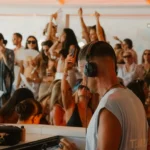 DJ in headphones playing to a dancing crowd at Nikki Beach Saint Barth