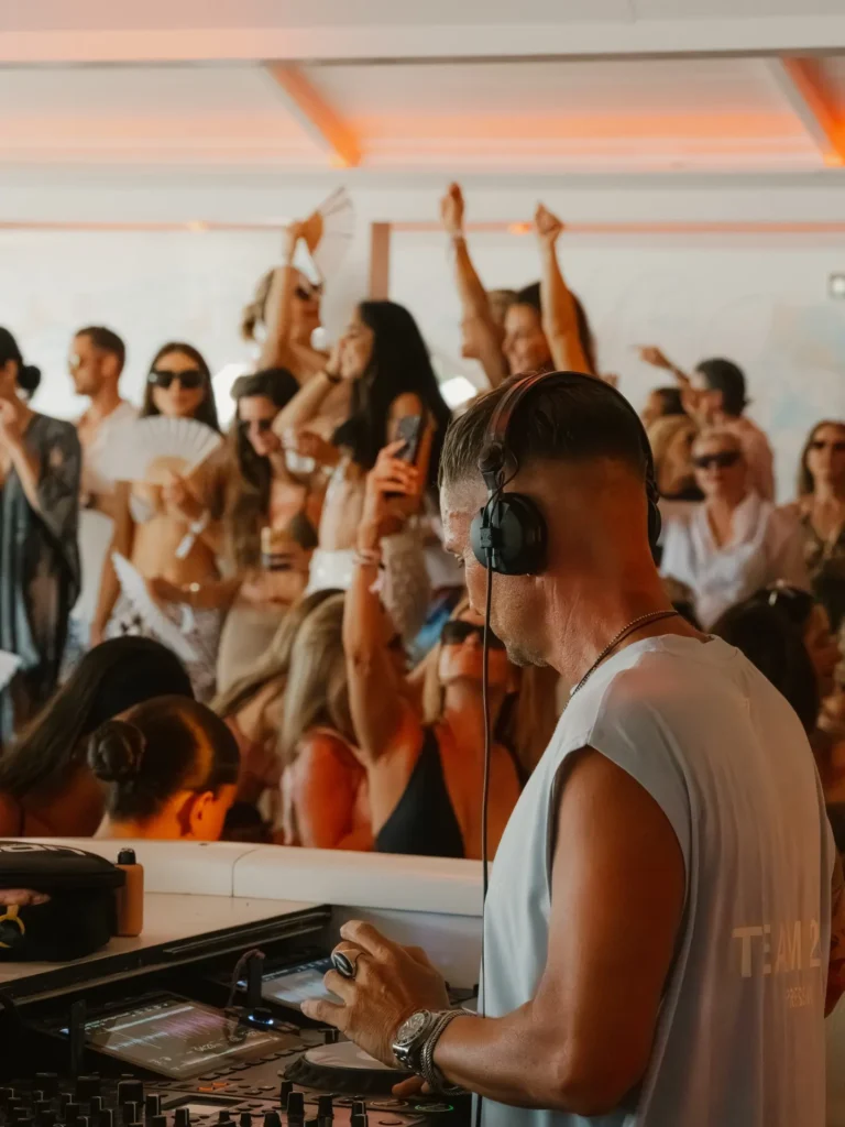DJ in headphones playing to a dancing crowd at Nikki Beach Saint Barth