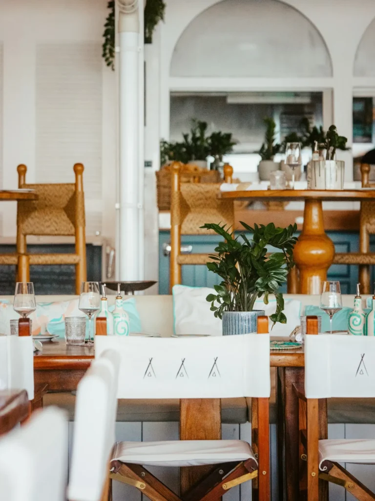 Wooden tables with rush-seat chairs and turquoise accents in the restaurant at Nikki Beach Saint Barth