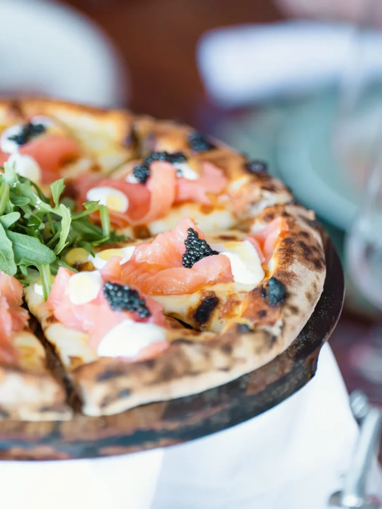 Wood-fired pizza topped with smoked salmon, cream and caviar at Nikki Beach Saint Barth