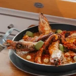 Seafood paella with prawns and octopus in a pan at Nikki Beach Saint Barth