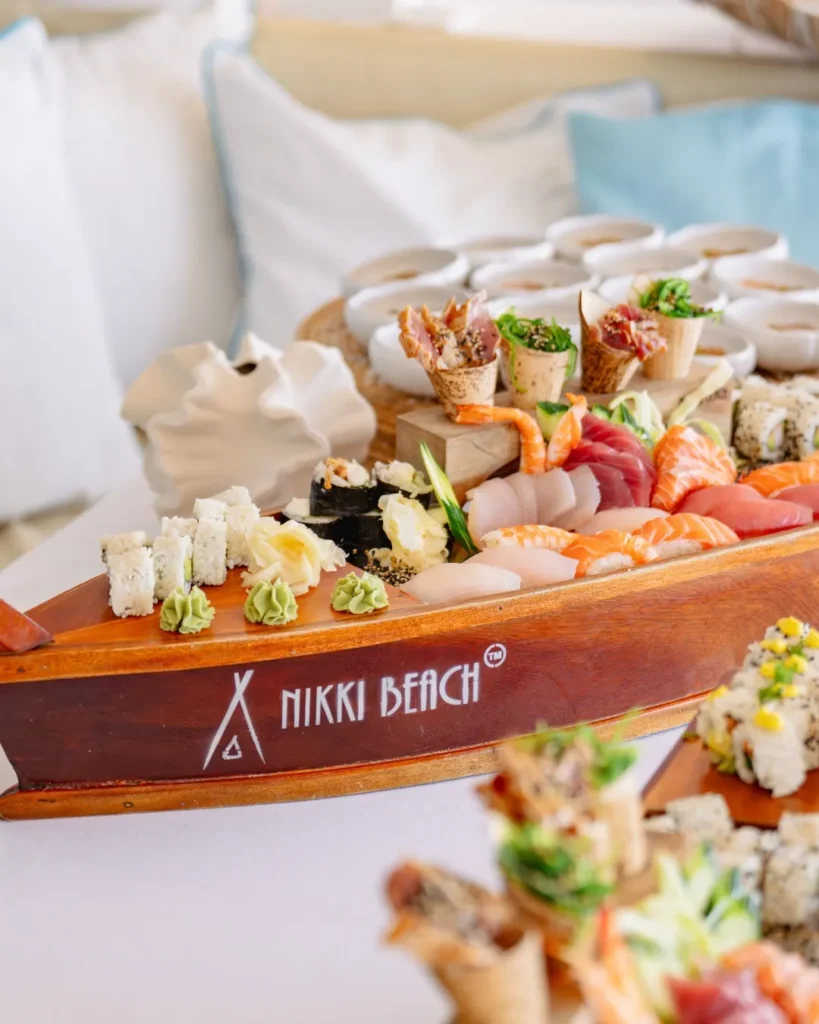Sushi and sashimi assortment served on a branded wooden boat platter at Nikki Beach Saint Barth