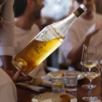 Server presenting a chilled bottle of rosé at a lunch table at Nikki Beach Saint Barth