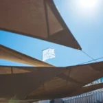 La Serena flag flying above the sail canopies against a blue sky at Plage La Serena Ramatuelle Saint-Tropez