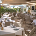 Restaurant tables under sail canopies beside the open kitchen at Plage La Serena Ramatuelle Saint-Tropez