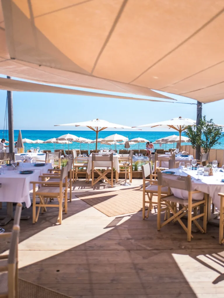 Restaurant deck with parasols opening onto the sea at Plage La Serena Ramatuelle Saint-Tropez
