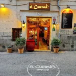El Cuerno storefront with an illuminated sign, wine barrel and fairy-lit doorway at Restaurante El Cuerno Palma
