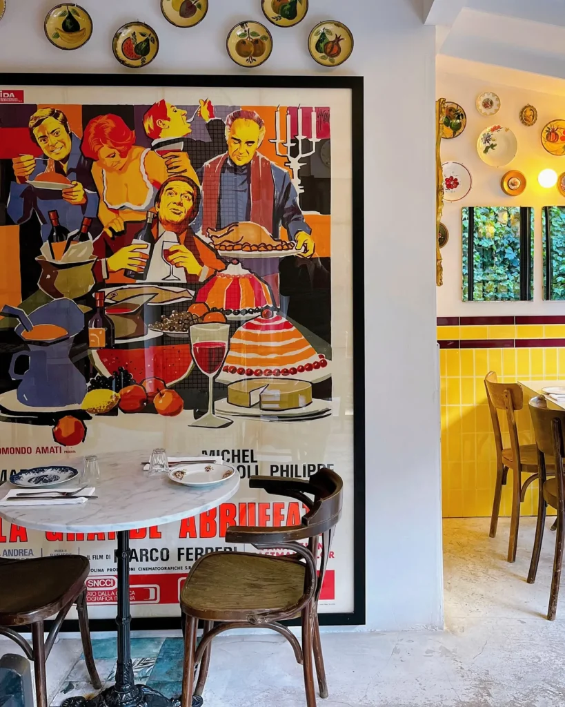 Dining room with a large vintage poster, plate wall and yellow-tiled corner at Rikito Palma