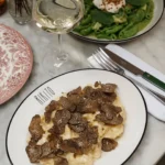Creamy pasta blanketed in shaved truffle beside a green pasta dish at Rikito Palma