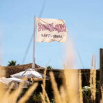 Shellona Saint-Tropez beach club flag flying above the beach club on a sunny day