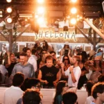 DJ performing to a crowd beneath the lit Shellona sign at Shellona Saint-Tropez