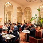 Busy dining area with arched windows and elegant decor at Siena Paris