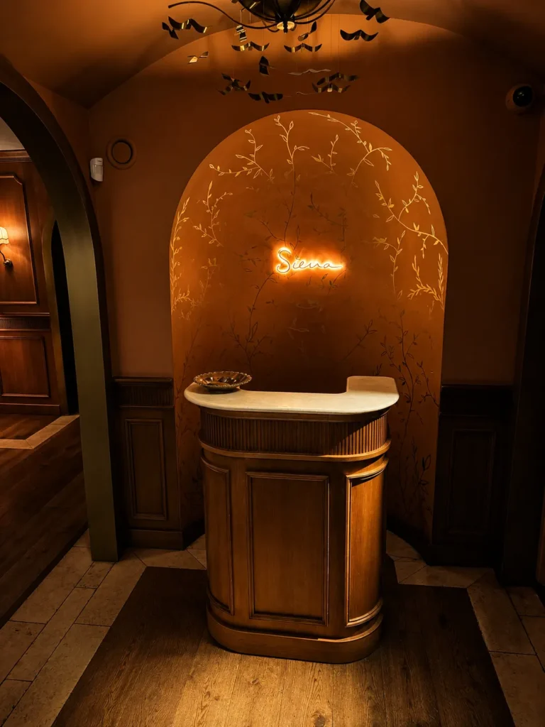Warmly lit entrance interior with Siena Paris signage