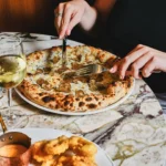 Guests enjoying freshly prepared pizza at Siena Paris