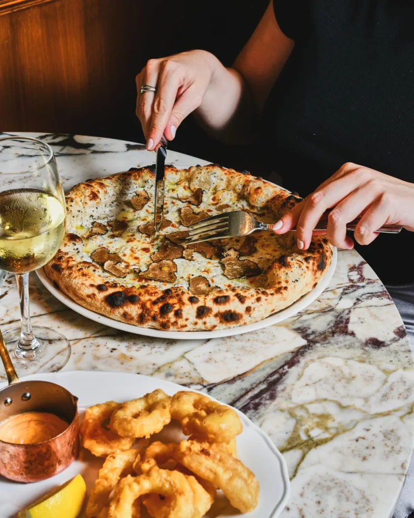 Guests enjoying freshly prepared pizza at Siena Paris