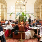 vElegant restaurant interior with arched windows and red seating at Siena Paris