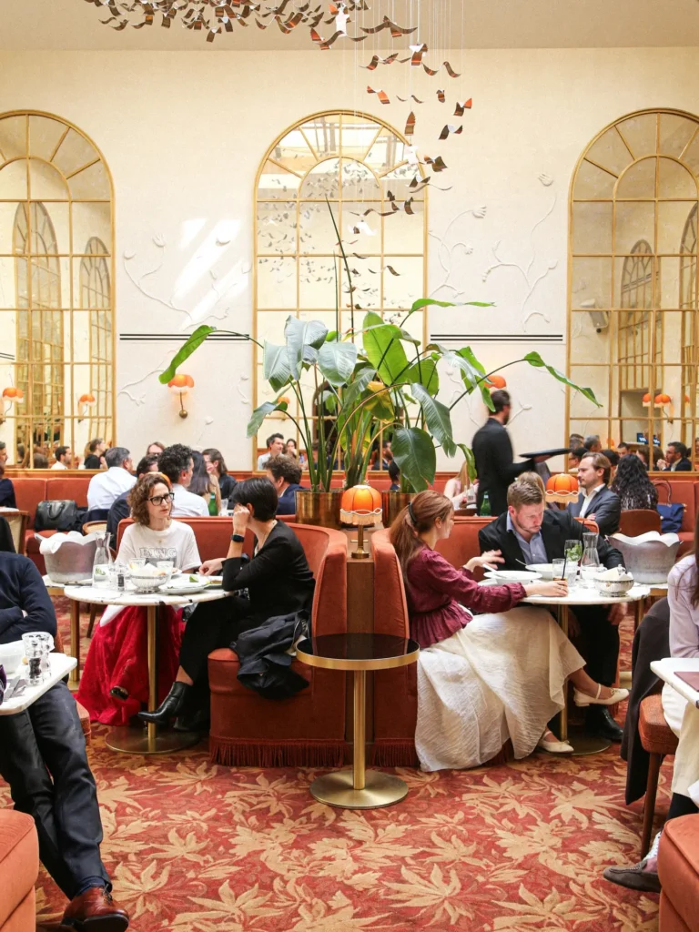 vElegant restaurant interior with arched windows and red seating at Siena Paris